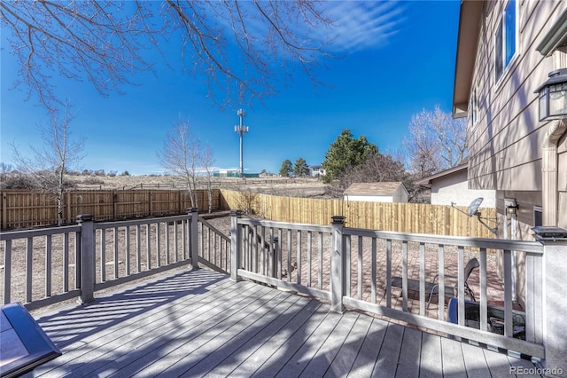 wooden terrace with a fenced backyard