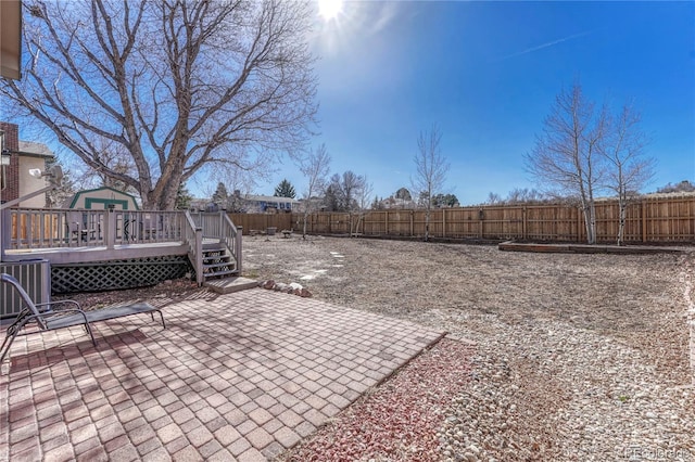 view of yard featuring a fenced backyard, a deck, central AC unit, and a patio