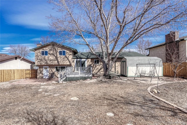 view of front of property with an outbuilding, a wooden deck, a storage unit, and a fenced backyard