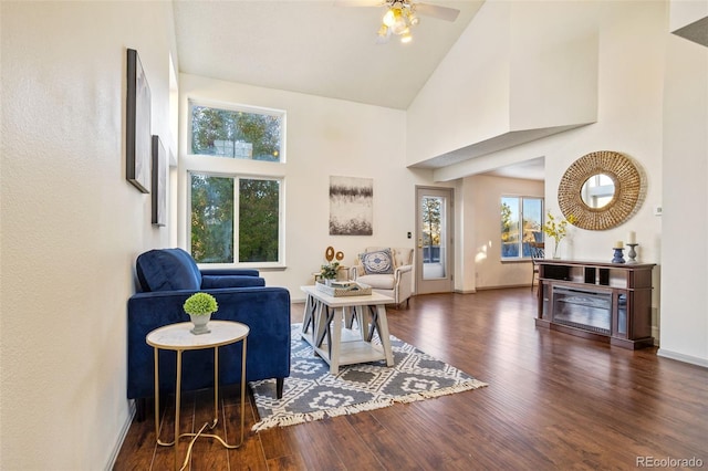 sitting room with dark hardwood / wood-style flooring, high vaulted ceiling, and ceiling fan