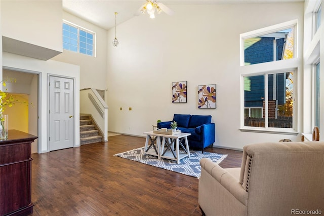 living room featuring dark hardwood / wood-style floors, high vaulted ceiling, and ceiling fan