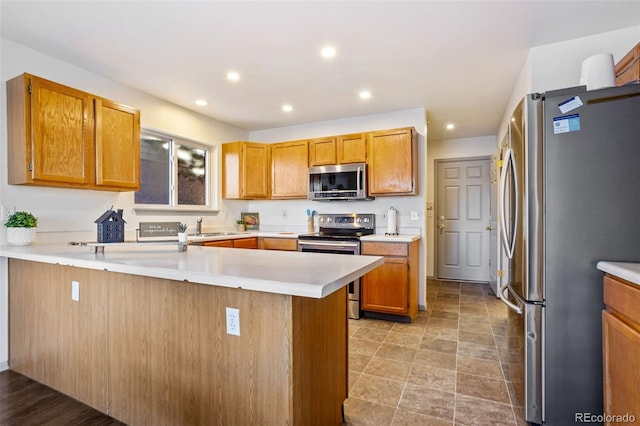 kitchen featuring kitchen peninsula, sink, and stainless steel appliances