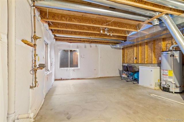 basement with water heater and white fridge