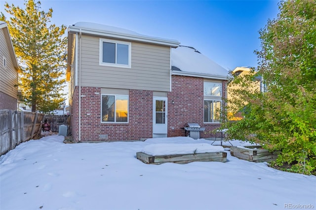 snow covered rear of property featuring cooling unit