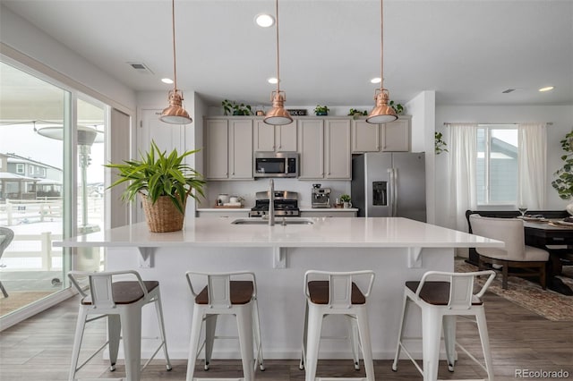 kitchen with pendant lighting, gray cabinetry, and appliances with stainless steel finishes