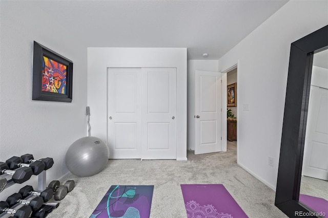 workout room featuring light carpet