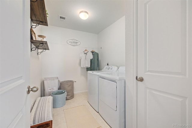 laundry area featuring light tile patterned floors and washer and clothes dryer