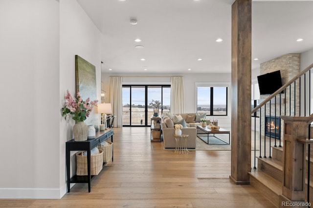 living room with light wood finished floors, stairs, baseboards, and recessed lighting