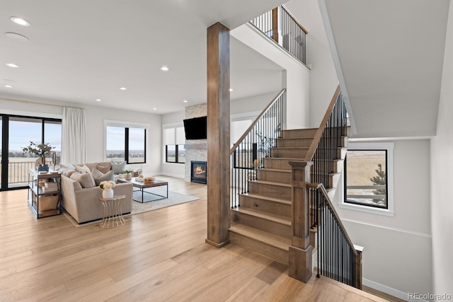 living area featuring a fireplace, recessed lighting, stairway, wood finished floors, and baseboards