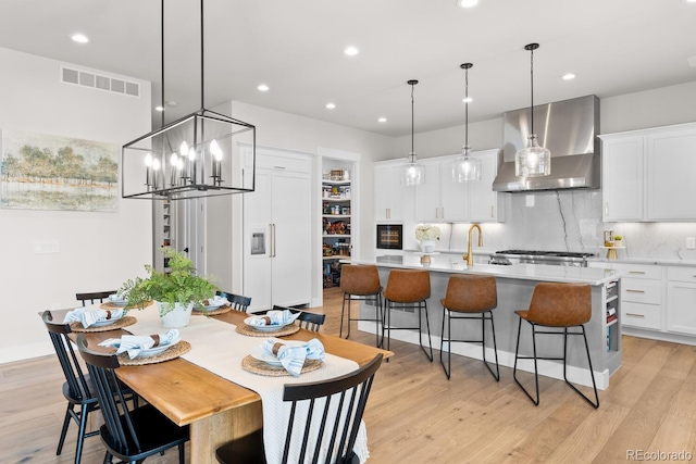 dining area featuring recessed lighting, visible vents, light wood finished floors, and an inviting chandelier