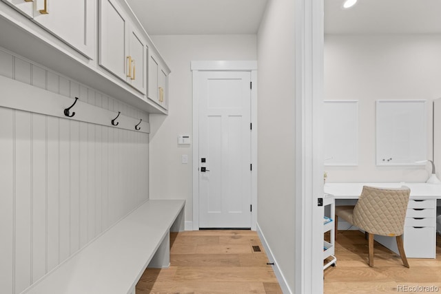 mudroom featuring baseboards and light wood finished floors