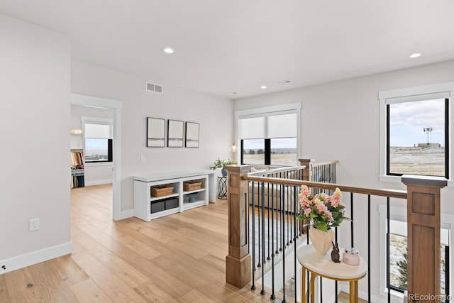 corridor with recessed lighting, an upstairs landing, baseboards, visible vents, and light wood finished floors