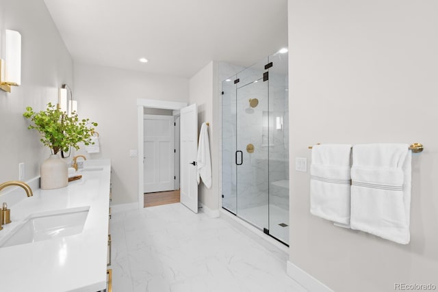 bathroom with marble finish floor, a sink, a marble finish shower, and baseboards