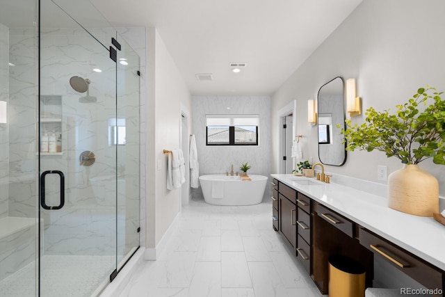 bathroom with visible vents, vanity, a freestanding bath, marble finish floor, and a marble finish shower