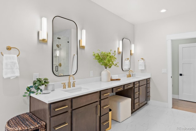 full bath featuring marble finish floor, baseboards, a sink, and a stall shower