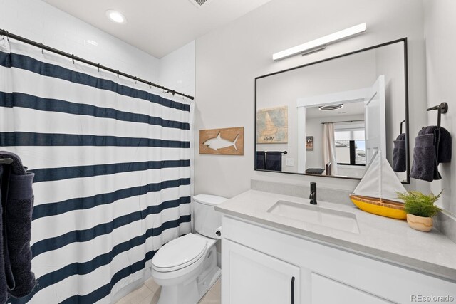 bathroom with curtained shower, vanity, and toilet