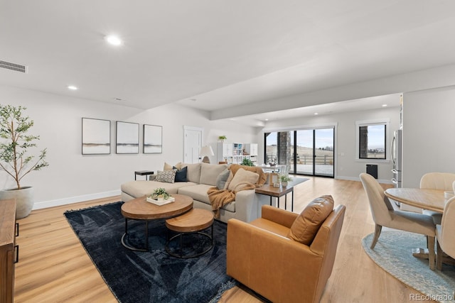 living area with recessed lighting, baseboards, visible vents, and light wood finished floors