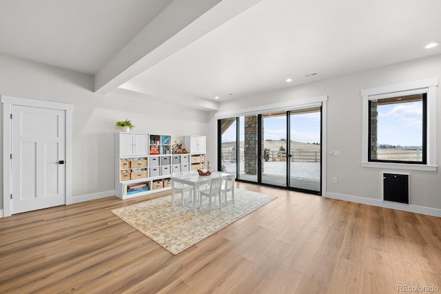 living area featuring recessed lighting, baseboards, beamed ceiling, and light wood finished floors