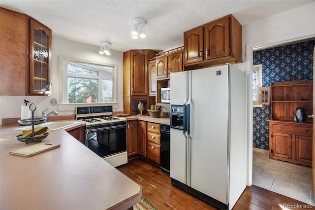 kitchen featuring dark hardwood / wood-style floors, sink, white appliances, and a textured ceiling