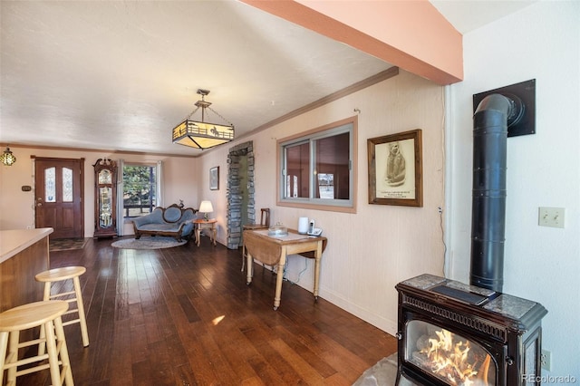 interior space featuring dark hardwood / wood-style floors, a wood stove, and ornamental molding