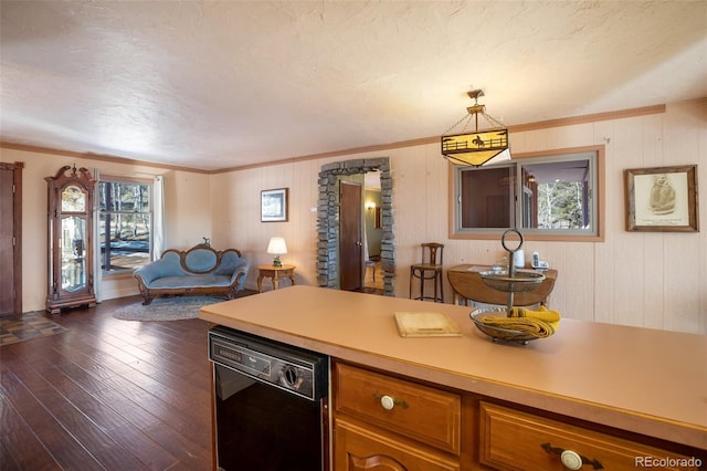 kitchen featuring ornamental molding, dark hardwood / wood-style flooring, hanging light fixtures, and black dishwasher