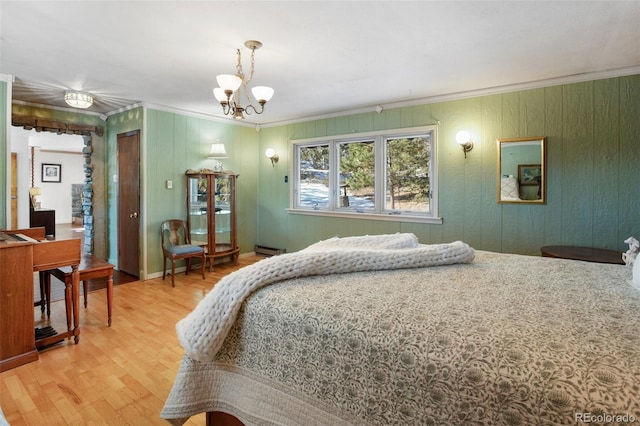 bedroom with a chandelier, wood-type flooring, a baseboard radiator, and ornamental molding