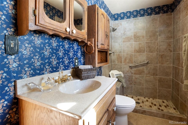 bathroom with tile patterned floors, vanity, toilet, and tiled shower