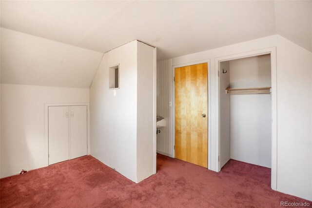 unfurnished bedroom with carpet floors and lofted ceiling