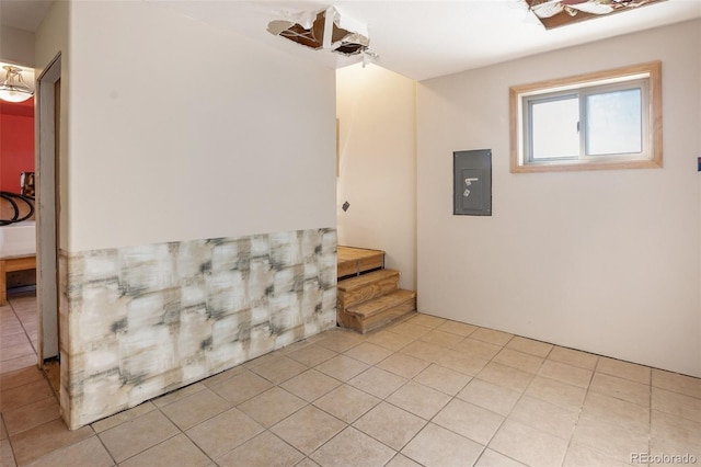 interior space with light tile patterned flooring and electric panel