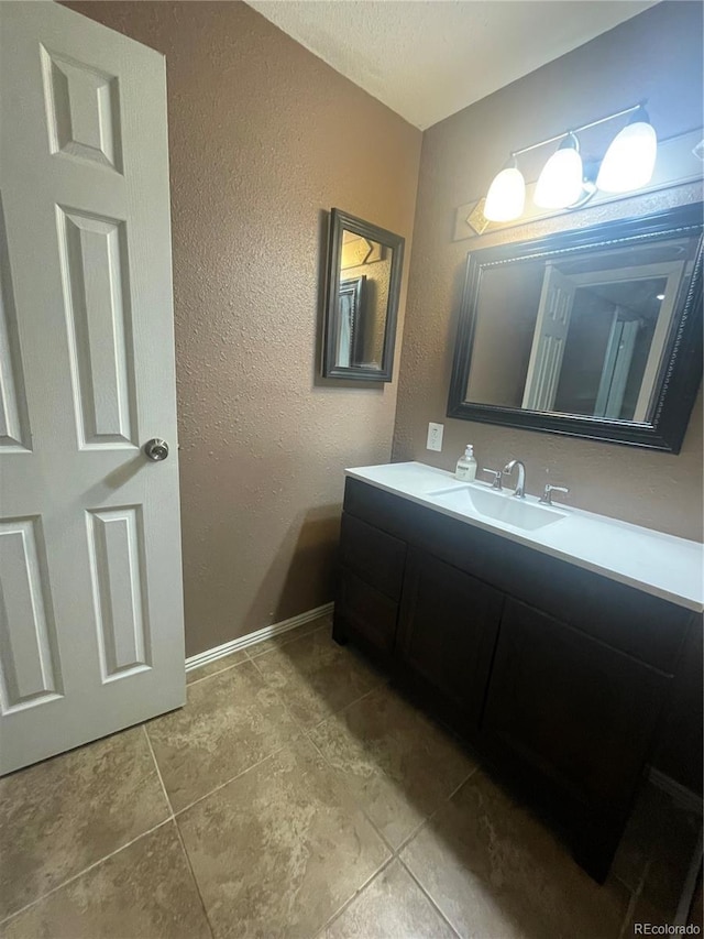 bathroom with tile patterned floors, vanity, and a textured ceiling