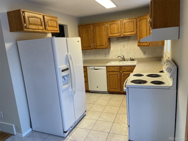 kitchen with light tile patterned flooring, sink, backsplash, and white appliances