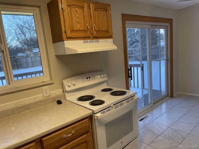 kitchen with light tile patterned floors, plenty of natural light, and white electric stove