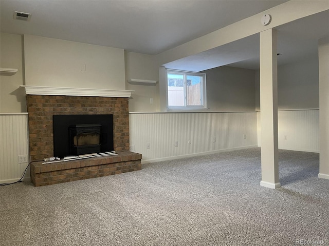 unfurnished living room featuring a wood stove and carpet flooring