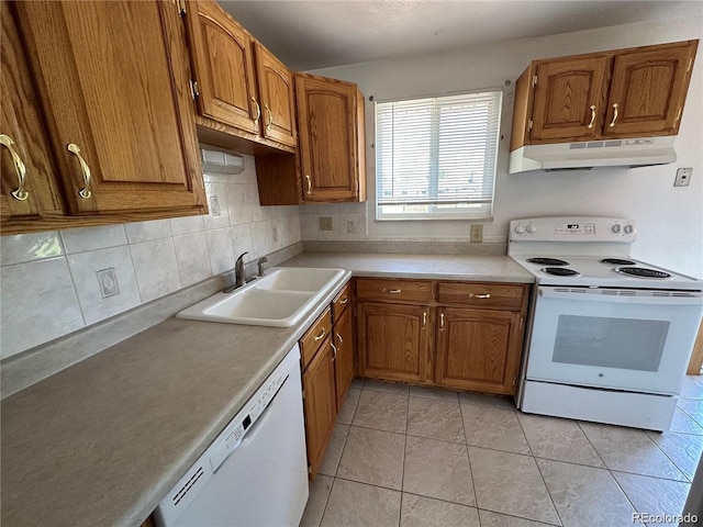 kitchen featuring light tile patterned floors, sink, tasteful backsplash, and white appliances