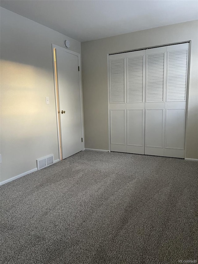 unfurnished bedroom featuring carpet floors and a closet