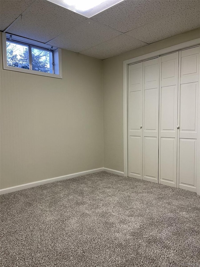 basement with carpet floors and a paneled ceiling