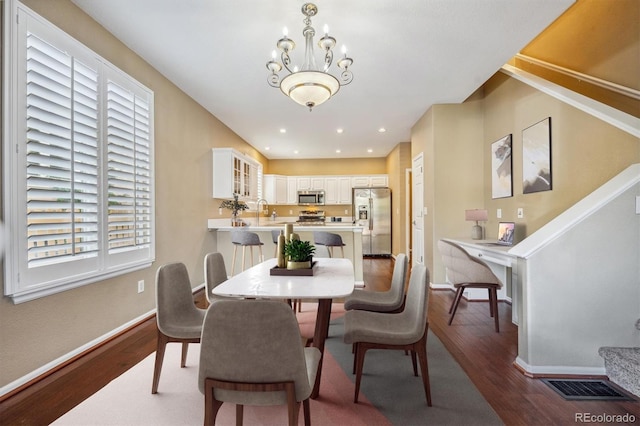 dining room featuring hardwood / wood-style flooring, a notable chandelier, and sink