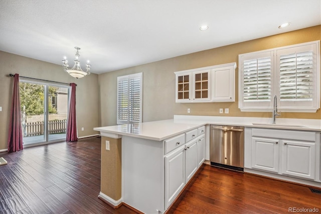 kitchen with stainless steel dishwasher, dark hardwood / wood-style floors, white cabinets, sink, and kitchen peninsula