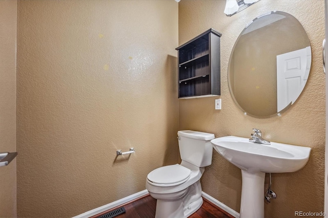 bathroom featuring hardwood / wood-style floors and toilet