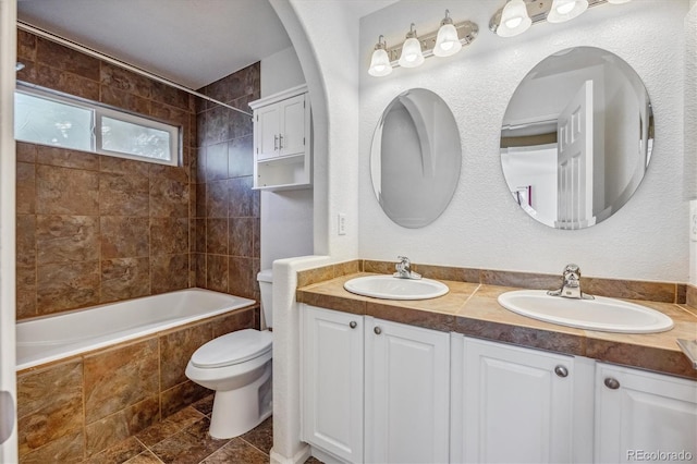 full bathroom with tiled shower / bath combo, tile patterned floors, vanity, and toilet