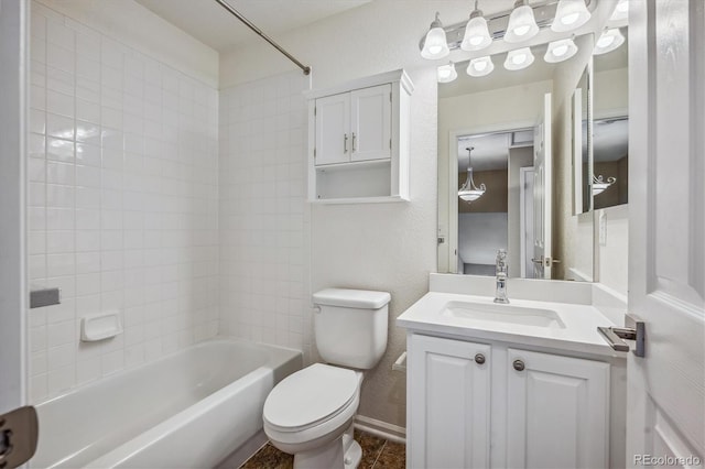 full bathroom with tiled shower / bath, vanity, and toilet