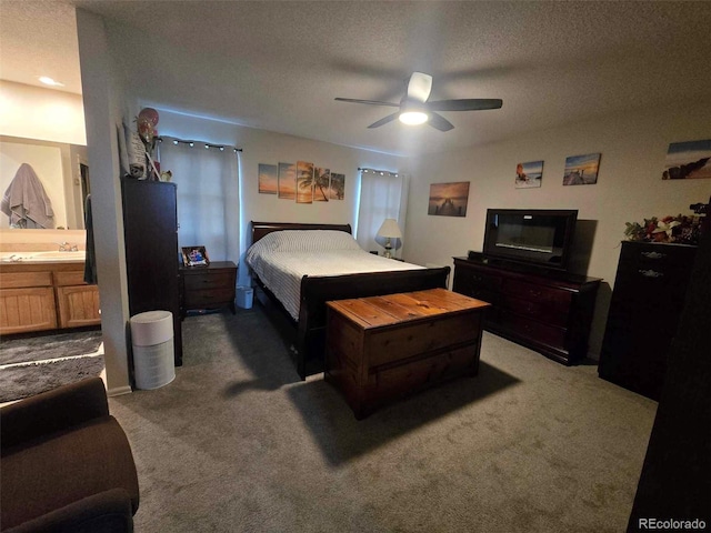 carpeted bedroom with ceiling fan, a textured ceiling, and ensuite bath