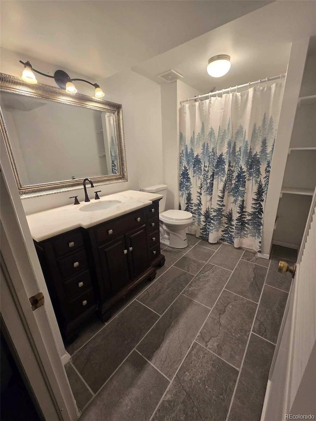 bathroom featuring visible vents, toilet, vanity, and a shower with curtain