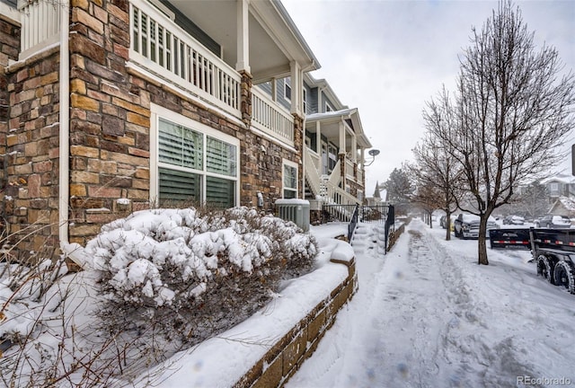 view of snowy exterior with central AC