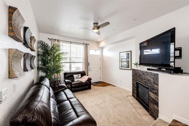 living room featuring ceiling fan, light colored carpet, and a fireplace