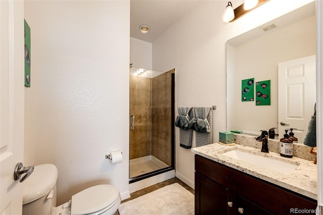 bathroom featuring vanity, an enclosed shower, and toilet