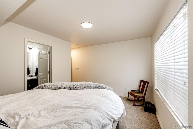 bedroom with ensuite bath and light carpet