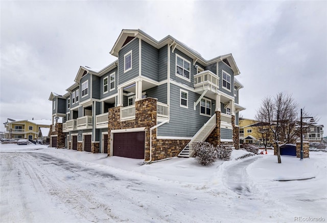 snow covered property with a garage