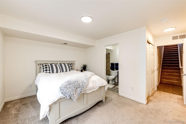 bedroom featuring light carpet, baseboards, and ensuite bath
