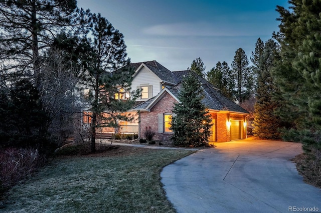 view of front of home featuring brick siding and concrete driveway